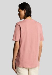 Lyserød kortærmet t-shirt med afslappet pasform, lavet af blødt stof, med rund halsudskæring og subtil tekstur. Ensfarvet rygdesign.