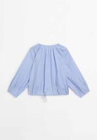Blouse bleu clair en tissu texturé. Caractéristiques : manches longues, encolure froncée, et ourlet à cordon de serrage pour un ajustement modulable.