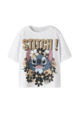 Hvid T-shirt med stort billede af tegneseriefiguren Stitch omgivet af beige og sorte blomster og ordet "STITCH!" i guldglitter øverst.