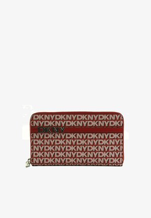 Portefeuille long rouge et beige à motif répétitif du logo DKNY, emblème métallique DKNY et fermeture éclair sur fond blanc.