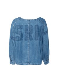 Lyseblå denimskjorte med oversized passform, senkede skuldre og "SRM" brodert i store bokstaver på baksiden. Lange ermer med mansjetter.