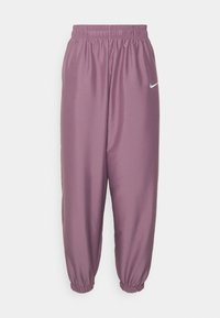 Lila Nike joggerbyxor med elastisk midja och mudd, med en vit Nike swoosh-logotyp på den övre låret.