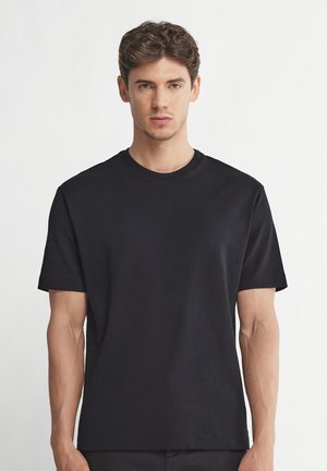 Sort bomulds t-shirt med rund hals og korte ærmer. Ensfarvet, glat tekstur, lige pasform uden synlige mønstre eller detaljer.