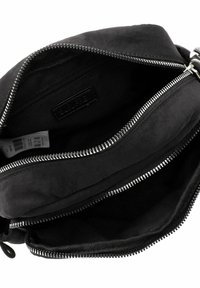 Borsa di stoffa nera con più scomparti con zip. Presenta cerniere in metallo argentato e una texture liscia, foderata con un tessuto interno di colore più scuro.