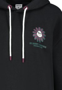 Schwarzer Hoodie mit weißen Kordeln und lila Akzenten. Verfügt über ein Blumenmotiv mit einem lächelnden Gesicht und dem Text "Sei glücklich zusammen."