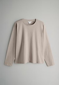 Ilgām piedurknei beigu krekls, kas izgatavots no mīksta kokvilnas, ar apaļu kakla izgriezumu un taisnu apakšmalu, ar minimālām šuvēm un bez redzamiem rakstiem.