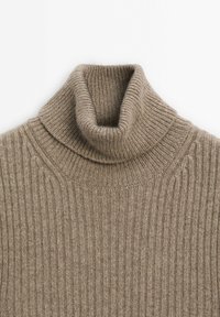 Beige ribbattu turtlenecki, jossa on korkea kaulus ja teksturoitu neulekuvio. Pehmeä, lämmin materiaali, jossa on pystysuuntaiset raidat ja tiukka malli.