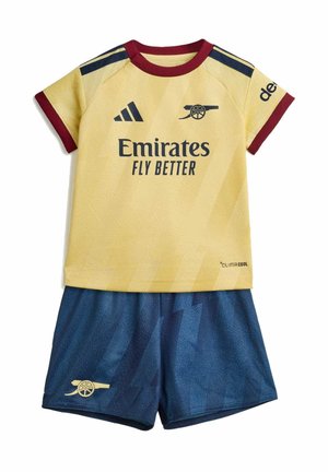Camiseta de manga corta amarilla y burdeos del Arsenal con pantalones cortos azules, con la marca Emirates Fly Better y logotipos de cañones.