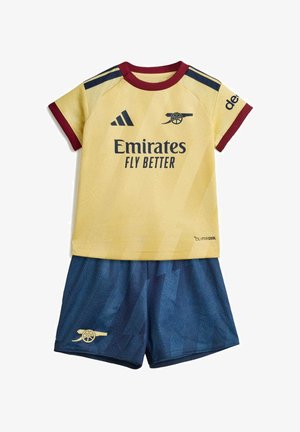 Camiseta de manga corta amarilla y burdeos del Arsenal con pantalones cortos azules, con la marca Emirates Fly Better y logotipos de cañones.