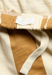 Odzież z mieszanki bawełny, z naprzemiennymi paskami beżowymi i brązowymi, elastycznym pasem w talii z białym guzikiem i sznurkiem do regulacji dla zapewnienia bezpiecznego dopasowania.