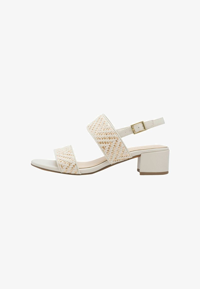 Sandale blanche à talon bloc avec deux brides tressées de couleur beige. Elle comporte une fermeture à boucle et une semelle lisse légèrement incurvée.