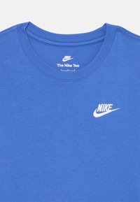 Tamnoplavina majica od mješavine pamuka s okruglim izrezom, s bijelim izvezenim Nike logotipom na lijevoj strani prsiju. Glatka tekstura, ležeran dizajn.