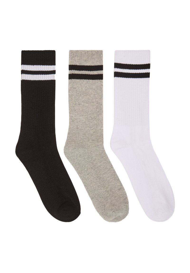 Tre paia di calze da crew in nero, grigio e bianco. Ogni calza presenta una texture a coste e due righe nere orizzontali nella parte superiore.
