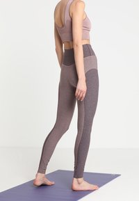 Lavendel sports bh og højtaljede leggings i varierende nuancer af mauve. Fremstillet af strækbart stof med sømløst design og sidelameller.