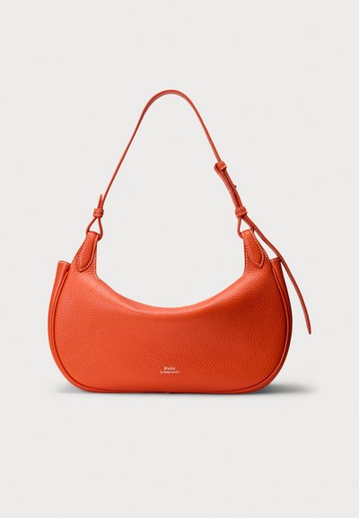 Sac à main en cuir orange de forme courbée, surface texturée, avec une bandoulière ajustable unique. Présente des coutures simples et un détail de logo.