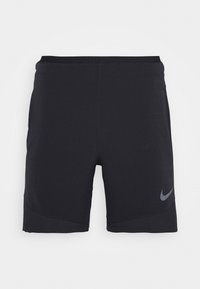 Black athletic shorts made from lightweight material, featuring a sleek design, side pockets, and a reflective Nike logo on the lower front.