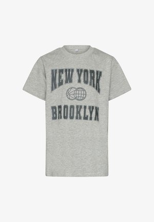 Szürke pamut póló kerek nyakkivágással. Sötét nyomattal rendelkezik a "NEW YORK" felirattal fent, és a "BROOKLYN" felirattal lent, középen pedig egy földgömb grafika található.