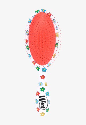 Brosse à cheveux avec une tête rembourrée rouge et un manche blanc à motif floral multicolore, étiquetée "Wet brush", avec des poils flexibles se terminant par des pointes rouges.
