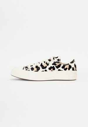 Witte canvas sneakers met een zwart en beige luipaardprint, platte rubberen zool en standaard vetersluiting.