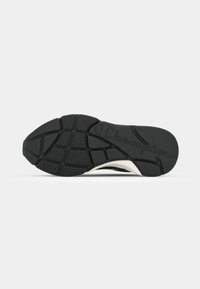 Black athletic shoe sole with textured rubber for grip, featuring a white midsole and "Champion" logo embossed on the surface.