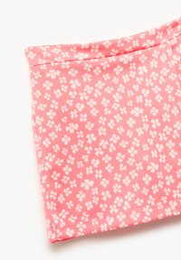 Rosa tyg med ett litet vitt blommönster, slät textur och vikt design, som visar konsekventa, upprepande motiv.