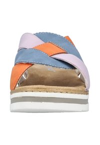 Colorful sandal featuring braided straps in light pink, blue, and orange. Soft suede material with a cushioned footbed and white sole.