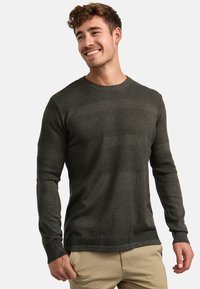 Maglione verde scuro con una trama tessuta e righe lisce a contrasto, scollatura rotonda e polsini a costine. Design aderente.