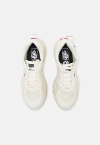 White mesh and leather sneakers with cream accents, round toe, and laces, featuring a black insole with 'VANS' logo and a red heel tab.