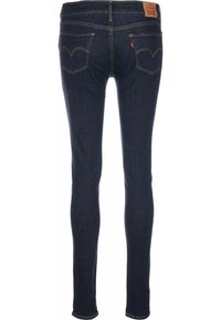 Jeans skinny azul oscuro de denim, con un clásico diseño de cinco bolsillos, costuras distintivas en los bolsillos traseros y una etiqueta de cuero.