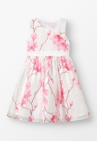Květinové šaty s bílým základem a potiskem růžových magnólií, bez rukávů, kulatý výstřih a pásek v pase. Vrstva s puntíkovanou texturou.