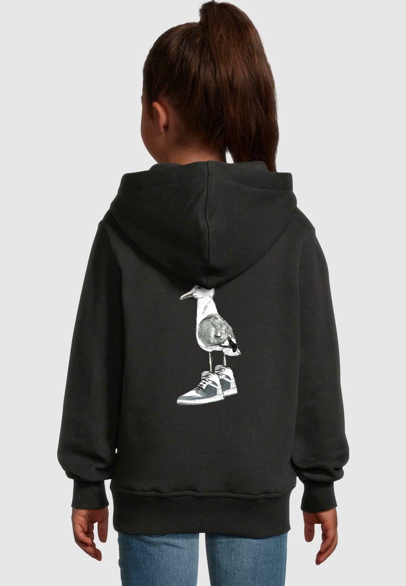 Czarna bluza z kapturem z grafiką ptaka stojącego na sneakersach z tyłu. Miękka tkanina, luźny krój oraz ściągacze przy mankietach i dolnym końcu.