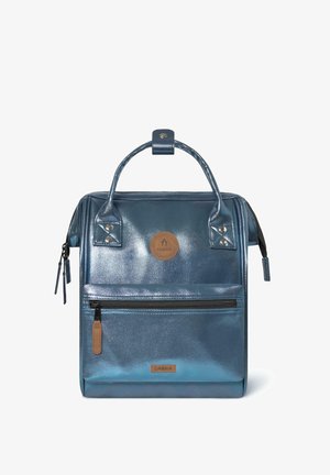 Metallisch blauer Rucksack mit zwei oberen Griffen, vorderer Reißverschlusstasche, Lederakzenten und geprägtem Logo-Patch. Glatte Textur und strukturiertes Design.