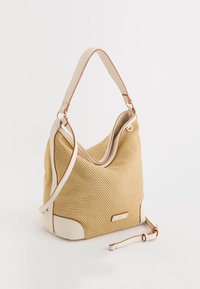 Woven straw shoulder bag w kolorze beżowym z białymi skórzanymi akcentami i zaokrąglonym kształtem. Posiada odczepiany pasek i subtelny detal z logo.