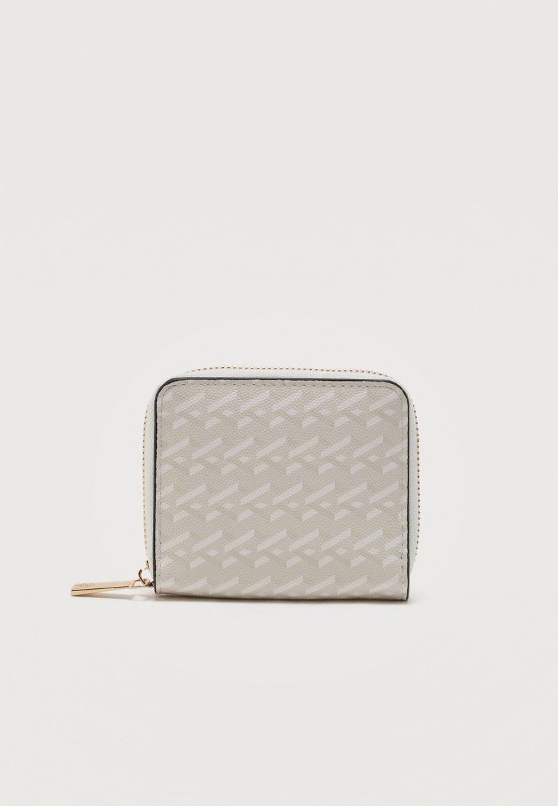 Portefeuille beige à fermeture éclair avec un motif géométrique répétitif subtil et un tire-zip doré, présenté sur un fond blanc uni.