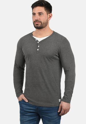 Long-sleeve gray henley shirt with a v-neck and three-button placket; soft, knit fabric; paired with blue jeans.