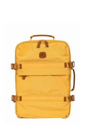Zaino rettangolare in tessuto giallo con manico in pelle, cinghie laterali regolabili, tasca frontale con zip e patch in pelle brandizzata sulla parte superiore frontale.