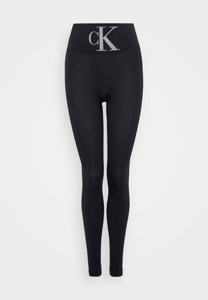 Leggings negros de tejido elástico con una cinturilla alta y el logo "cK" en plateado. Textura suave, diseño ajustado, sin patrones adicionales.
