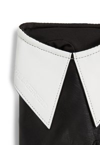 Stivale in pelle nera con colletto in pelle bianca, caratterizzato da un logo "KARL LAGERFELD" in rilievo sul lato.