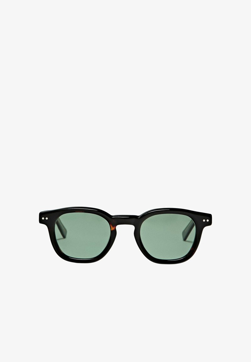 Black framed sunglasses with green tinted lenses and small silver dots near the hinges on each side.