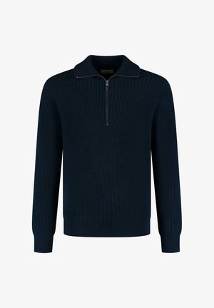 Tengerészkék bordás kötött pulóver cipzáras gallérral, hosszú ujjakkal és szűkített mandzsettával. A texturált anyag melegséget és kényelmet biztosít.