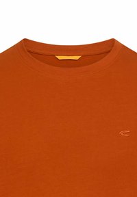 Rustfarvet crew neck T-shirt med et lille broderet logo på venstre bryst og en gul mærkat inden i nakken.