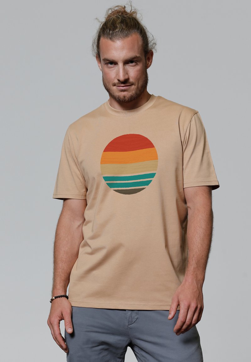 Beige katoenen t-shirt met een multiculturele cirkelvormige grafiek met horizontale strepen in rood, oranje, geel, teal en bruin.