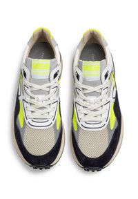 Sneaker sportive con tomaia in mesh e suede grigio, con accenti blu navy e giallo neon. Suola spessa con punti di trazione nera e chiusura con lacci.