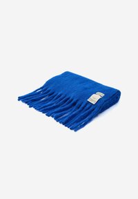 Felblau wollen sjaal met franjes, netjes gevouwen, met een wit label met tekst op een effen witte achtergrond.