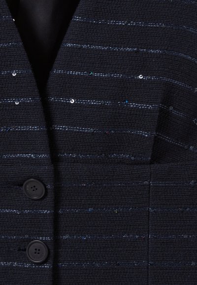 Blazer navy texturé avec un motif tissé, présentant des rayures métalliques et en sequins horizontales, et deux boutons noirs à l'avant.