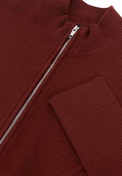 Maglione zip-up bordeaux con colletto alto, texture a costine e zip in argento. Le maniche si estendono dal corpo principale con un motivo a costine simile.