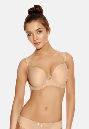 Beige gewatteerde bh met een gladde textuur, verstelbare bandjes en een klein strikdetail in het midden. Bijpassende slipjes zichtbaar, met een vergelijkbare kleur en stijl.