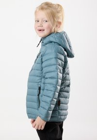 Ljust blå pufferjacka med huva, som har en quiltad design, dragkedjeficka och en texturerad yta.