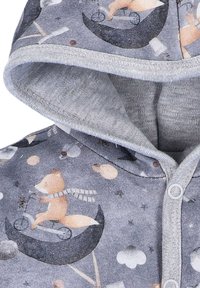 Grijze hoodie met een zachte textuur, voorzien van een gedrukt ontwerp van een vos op een scooter tegen een sterrenhemel. Inclusief drukknoopjes.