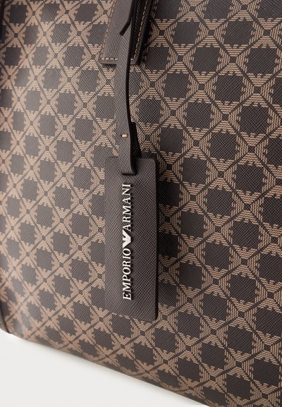 Καφέ σχεδιαστική τσάντα με μοτίβο και κρεμαστή μαύρη ετικέτα με ανάγλυφο το λευκό κείμενο "EMPORIO ARMANI".